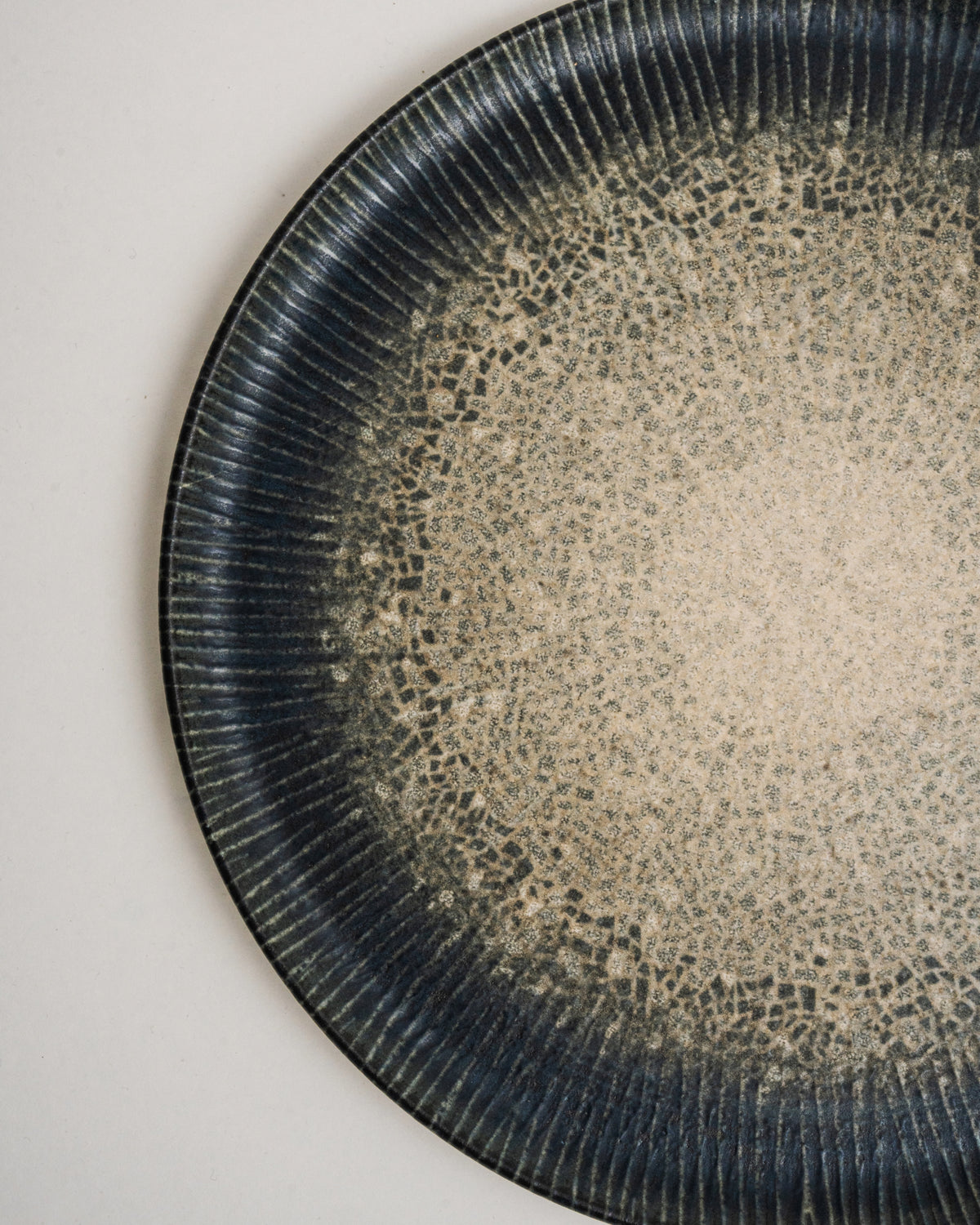 Tilted view of Arctic porcelain pizza plate, gradient pattern visible