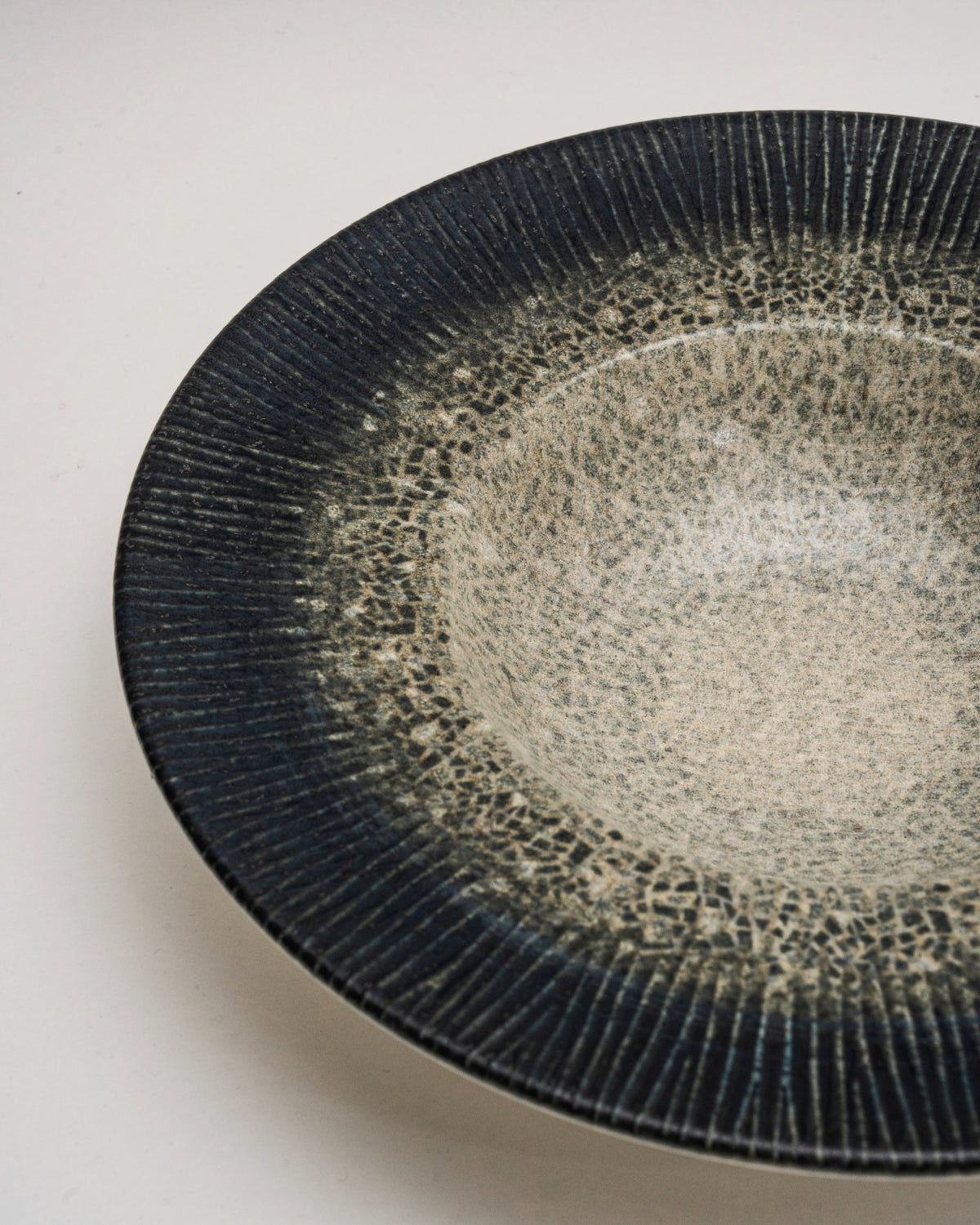 Overhead view of Arctic porcelain banquet plate, speckled texture detail