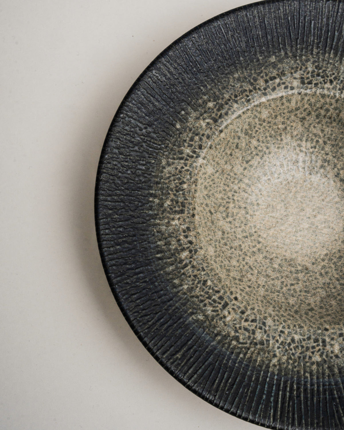 Close overhead view of Arctic porcelain banquet plate, black and white glaze