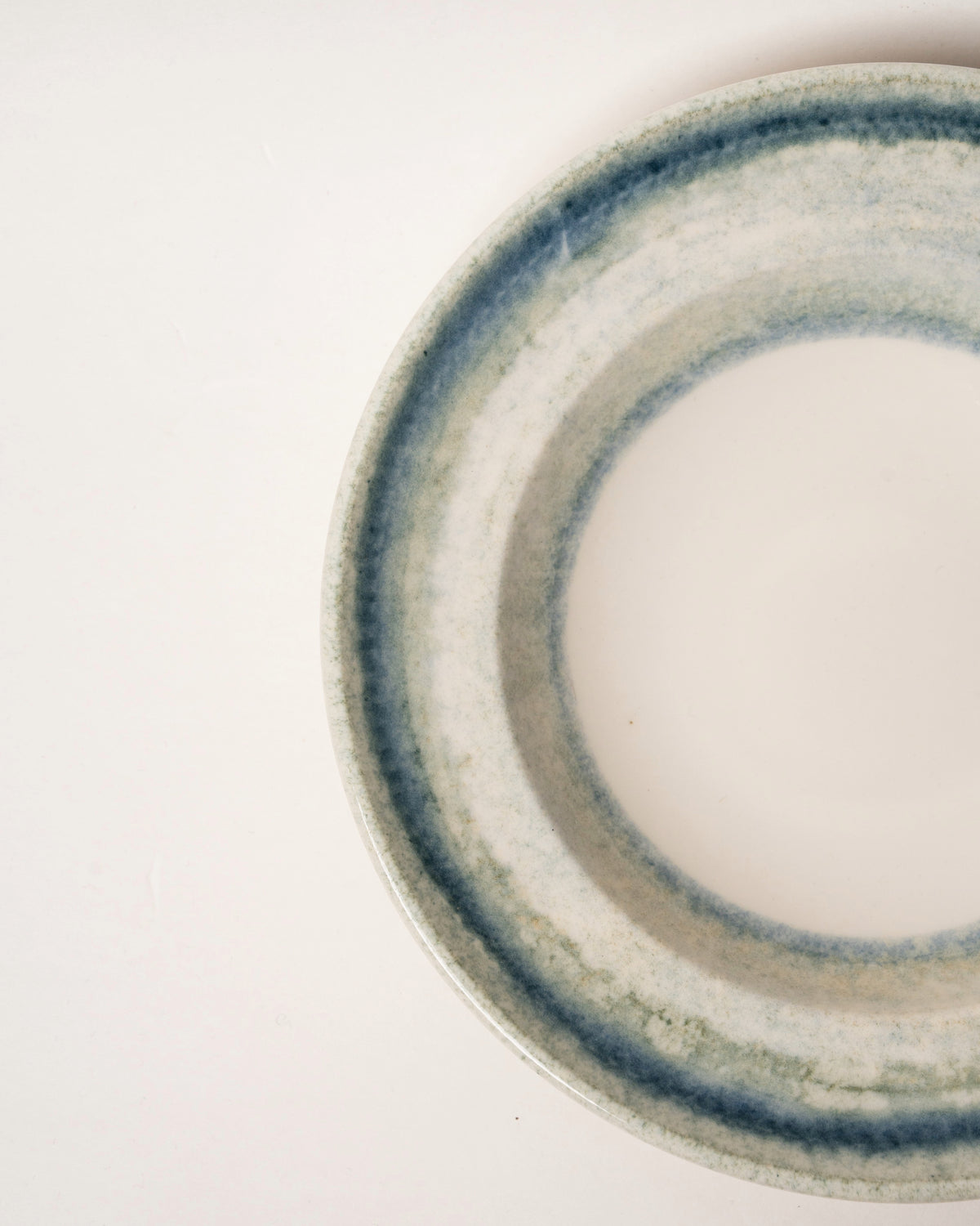 Close-up of Atlantis porcelain bistro bowl rim, blue glaze texture