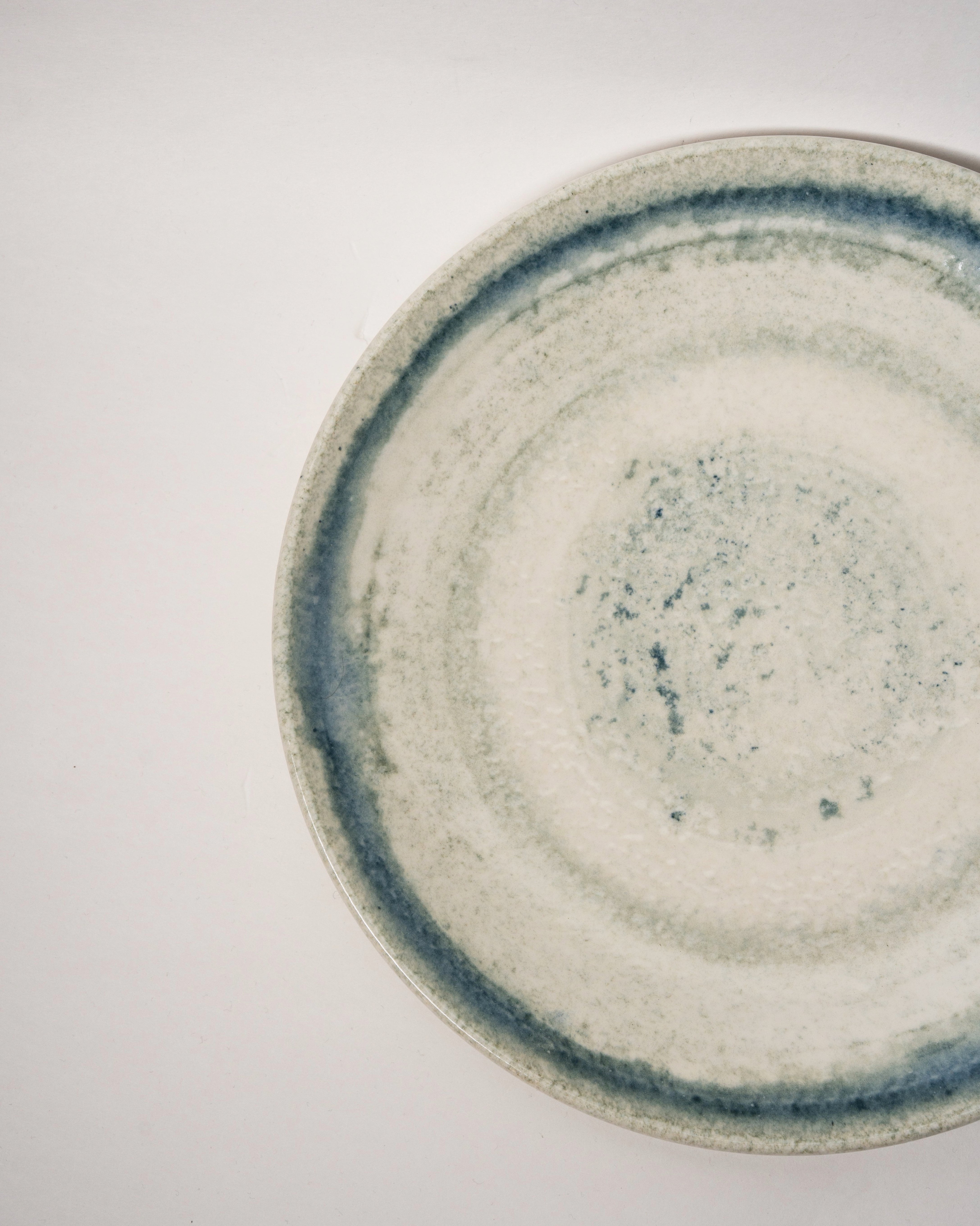 Close-up of Atlantis porcelain dinner plate rim showing blue glaze edge