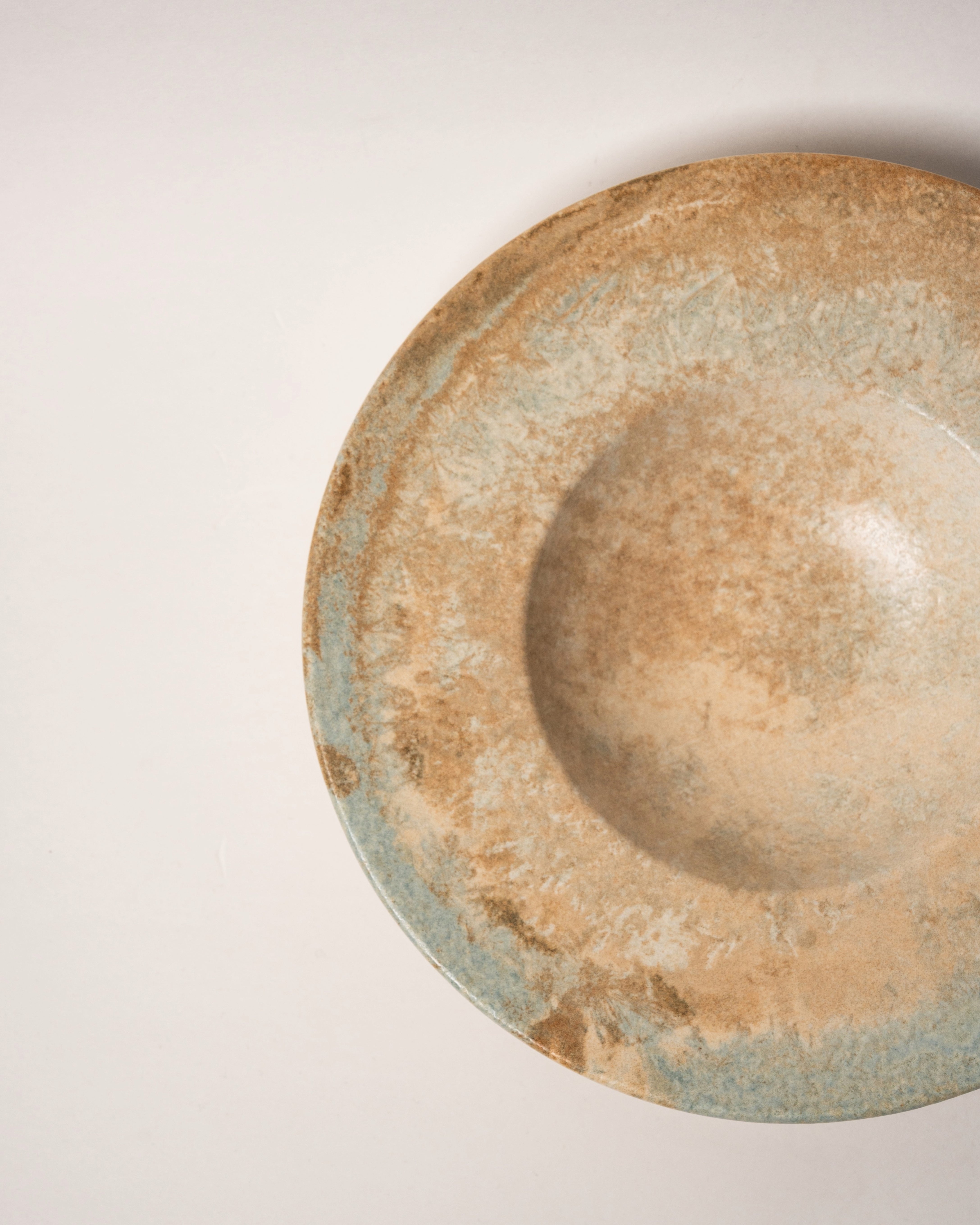 Angled view of Aurelia porcelain banquet plate showing bronze glaze detail