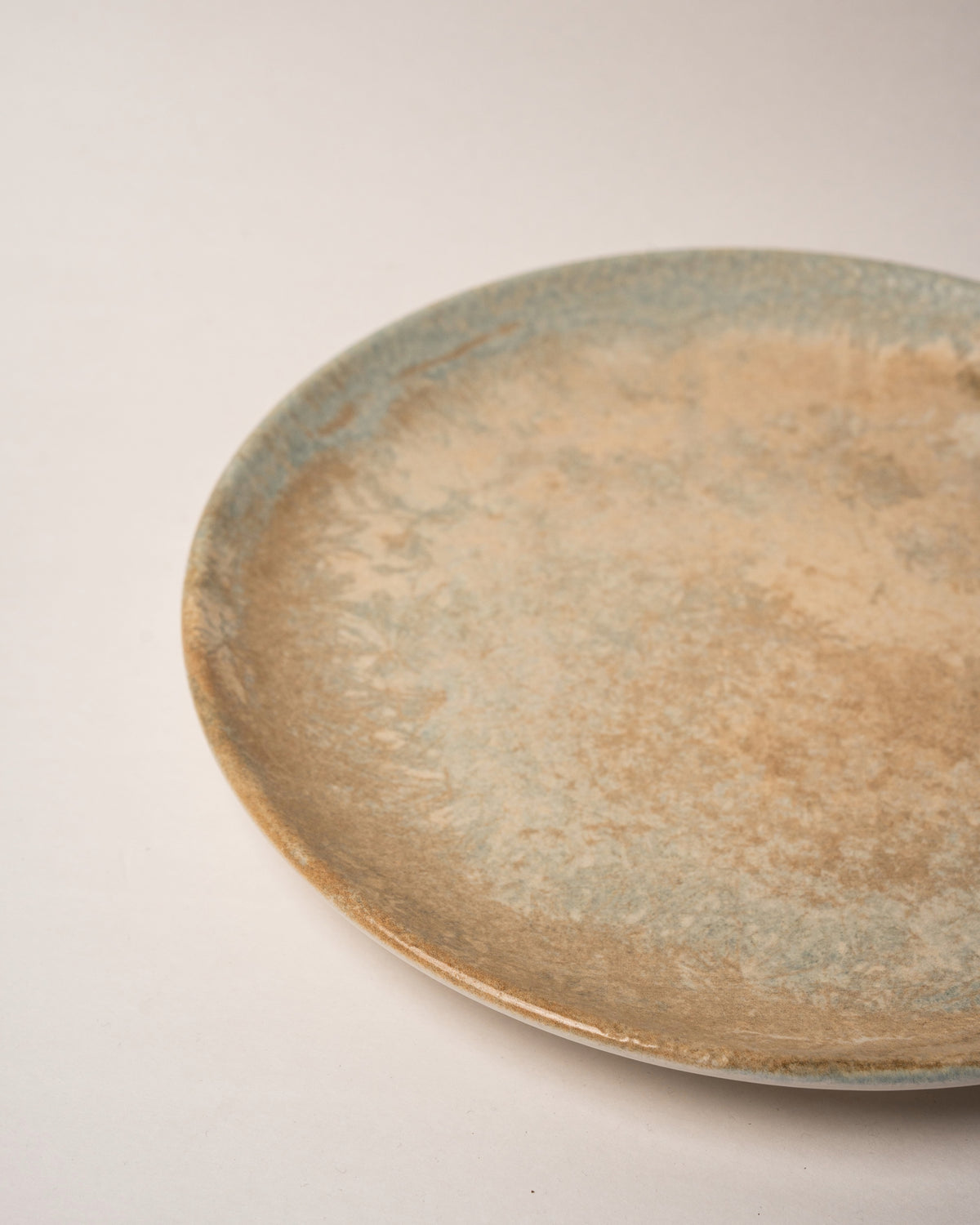 Side view of Aurelia porcelain dinner plate, bronze-toned finish