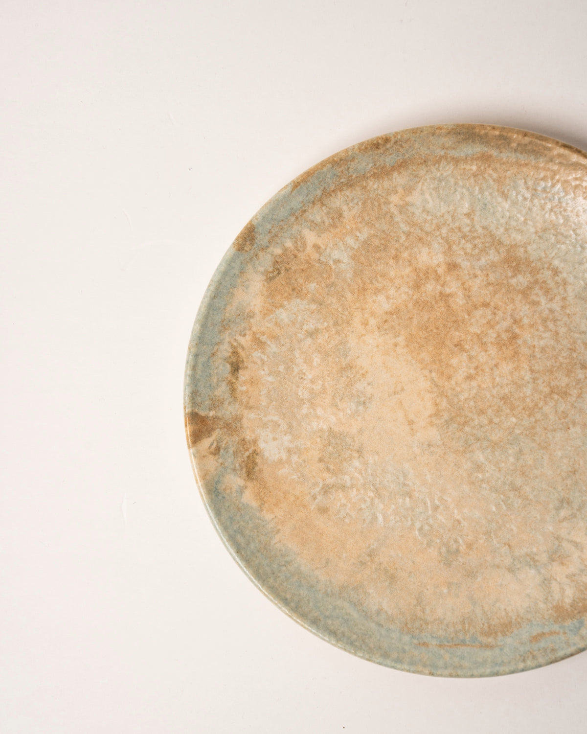 Overhead view of Aurelia porcelain dinner plate, bronze-toned finish