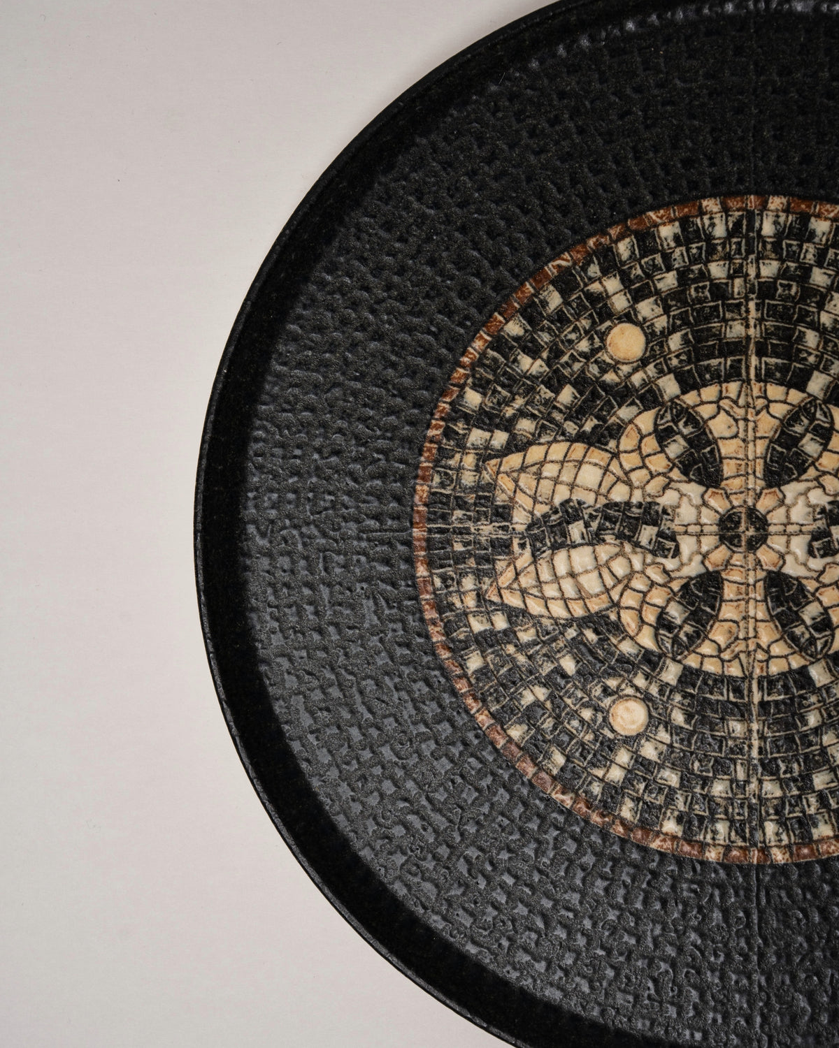 Angled view of Bee Mosaïque Black porcelain dinner plate, black and gold finish