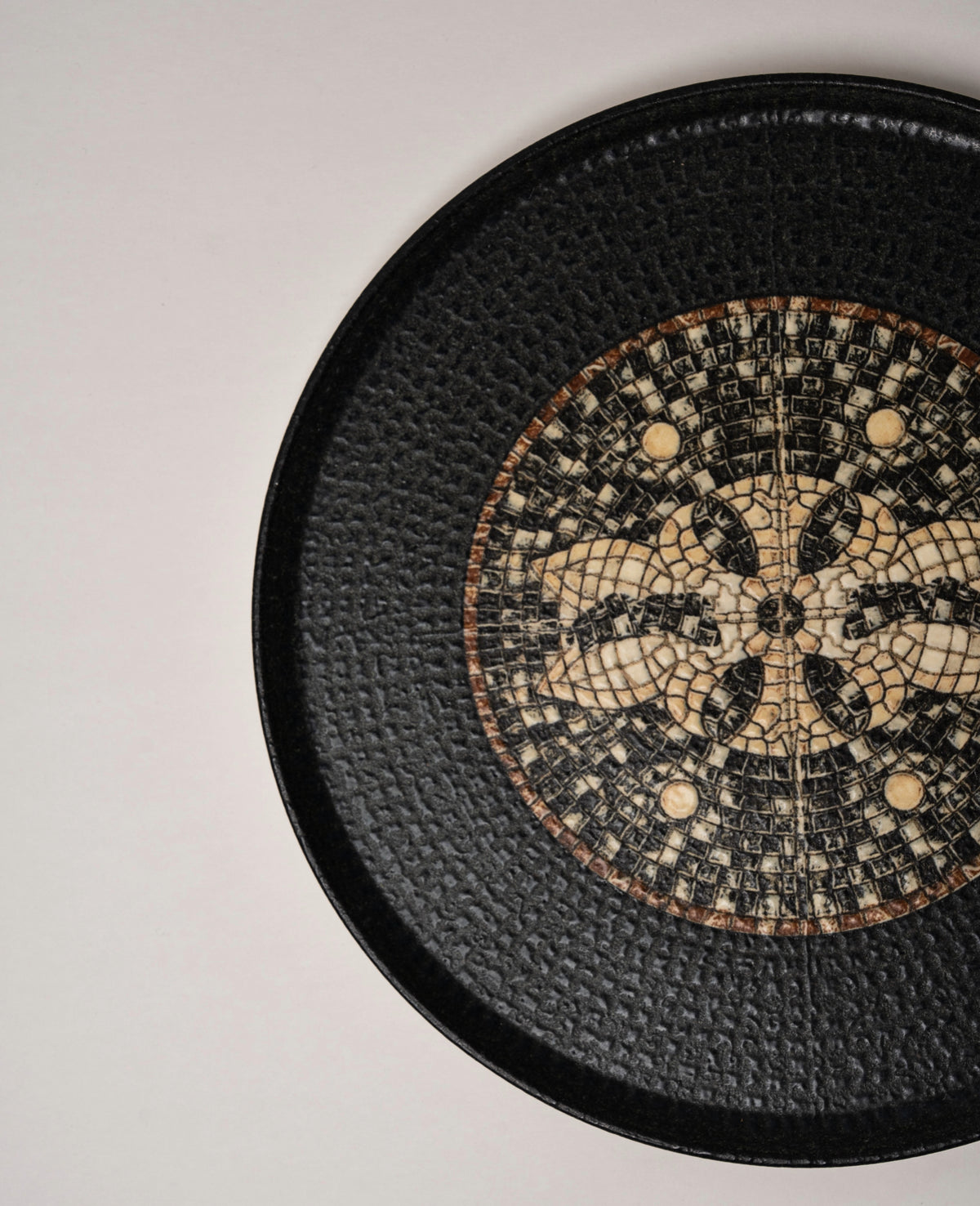 Tilted view of Bee Mosaïque Black porcelain dinner plate showing pattern