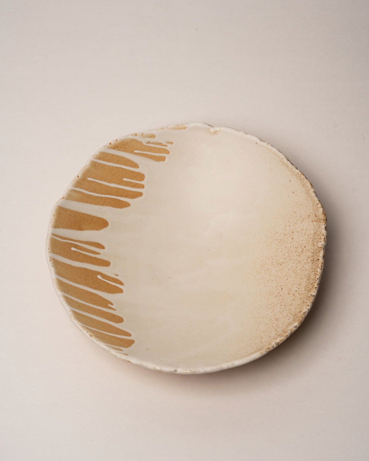 Close overhead view of Caramel porcelain bistro bowl, drizzle glaze texture