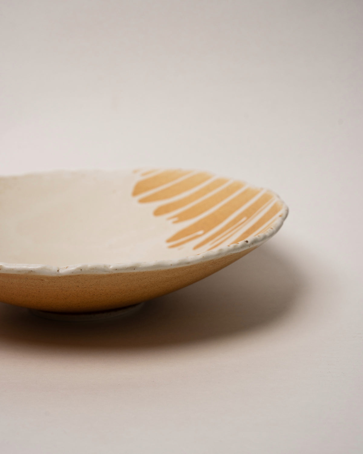 Side profile of Caramel porcelain bistro bowl, caramel drizzle visible