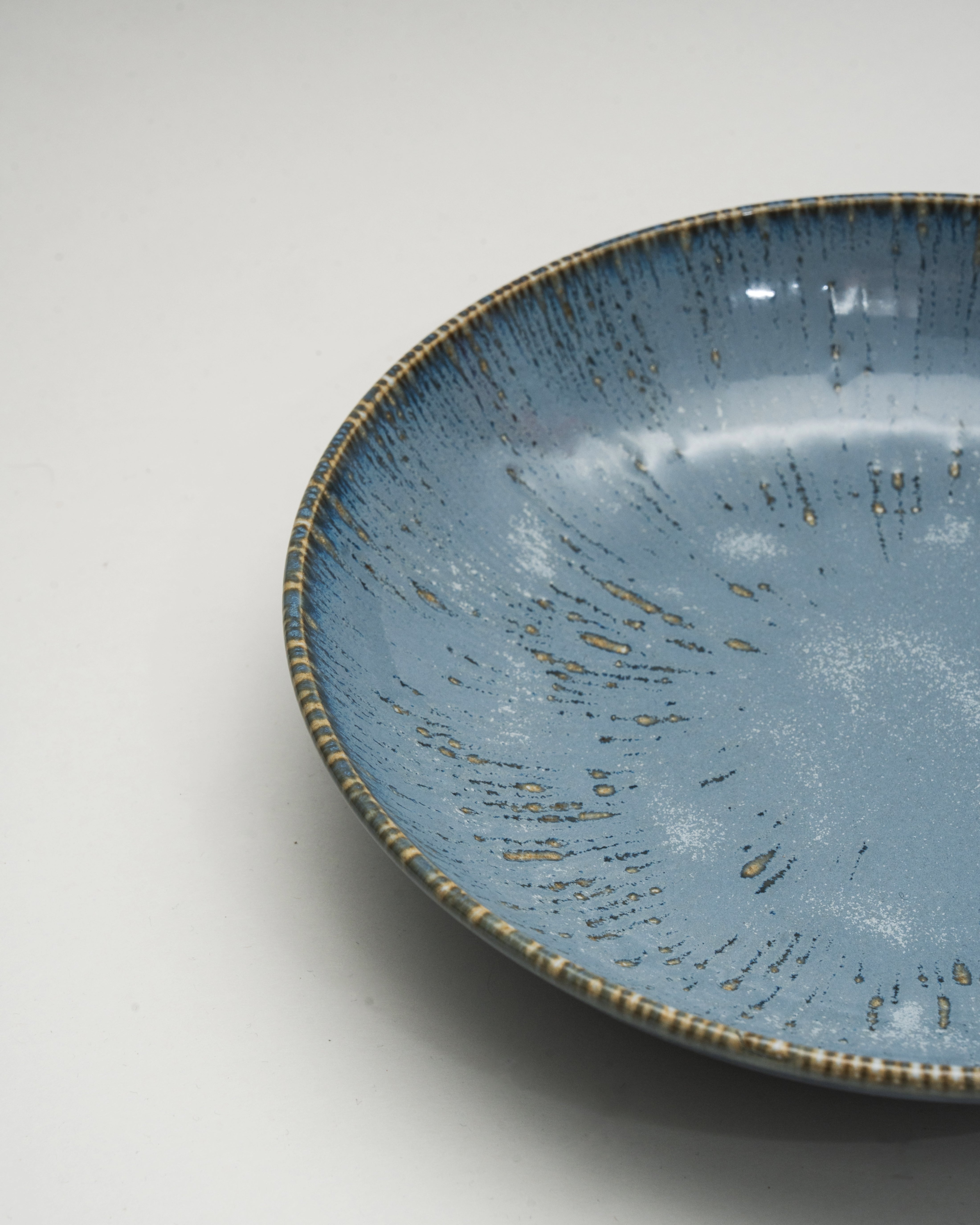 Angled view of Colosseum Aqua porcelain bistro bowl showing gold rim detail
