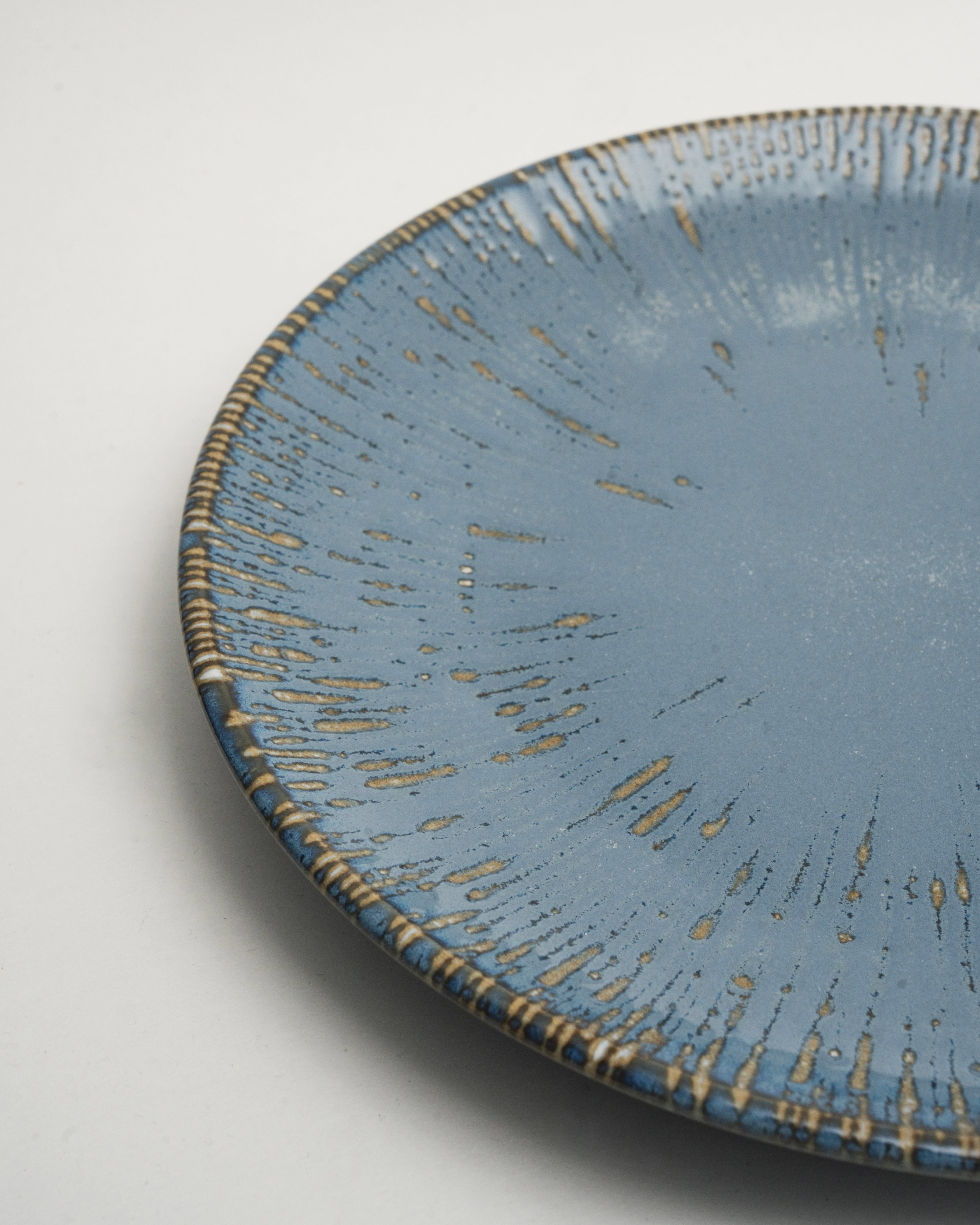 Angled view of Colosseum Aqua porcelain dinner plate showing gold rim detail