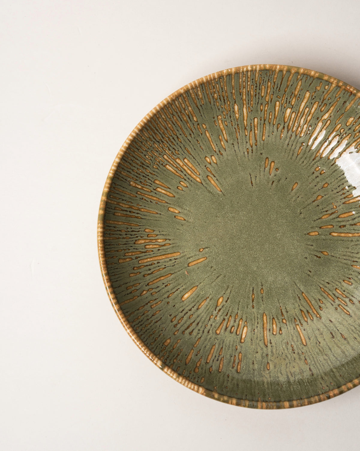 Angled view of Colosseum Verdant porcelain bistro bowl, olive-green finish
