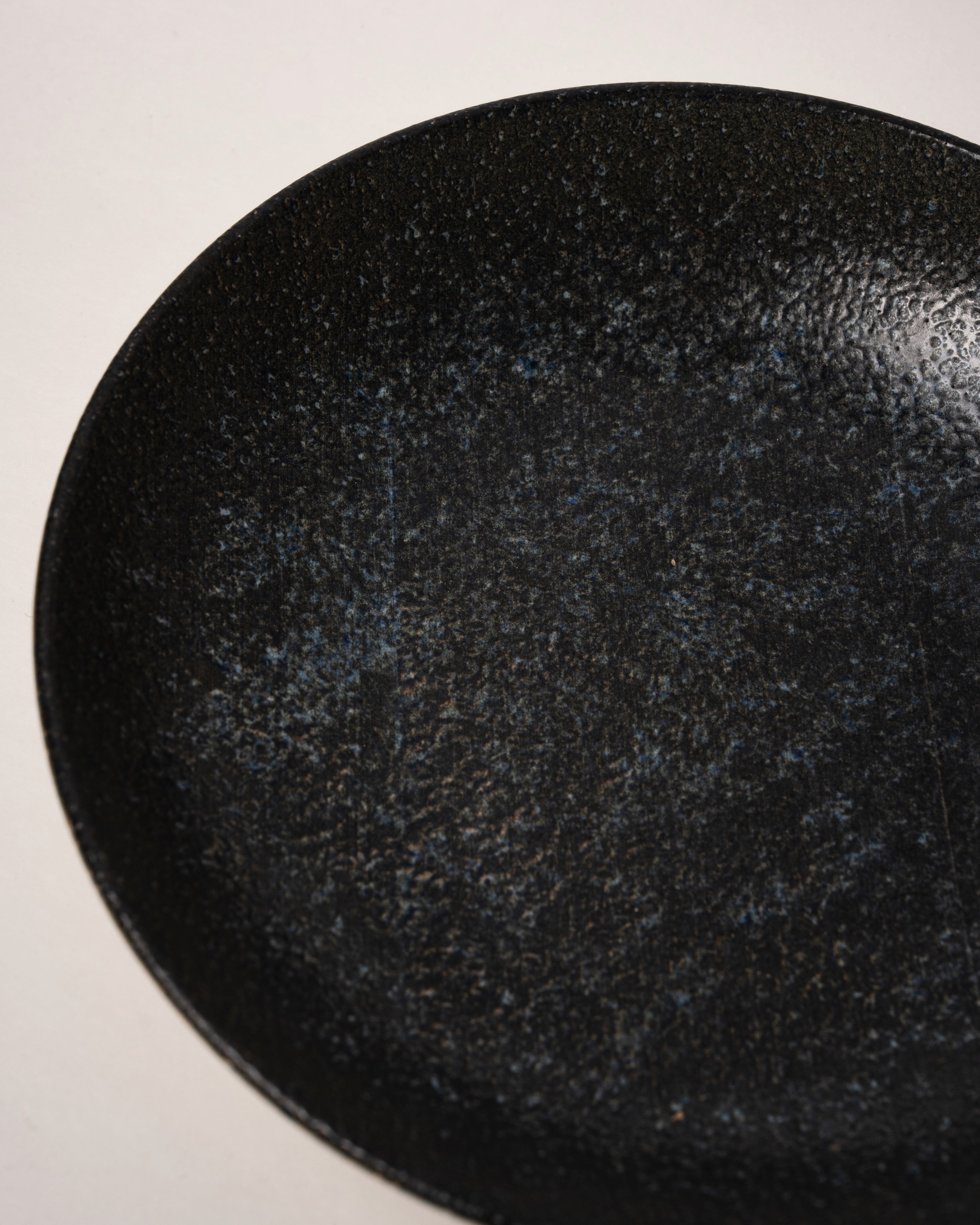 Overhead view of Cosmos porcelain bistro bowl showing black speckled glaze