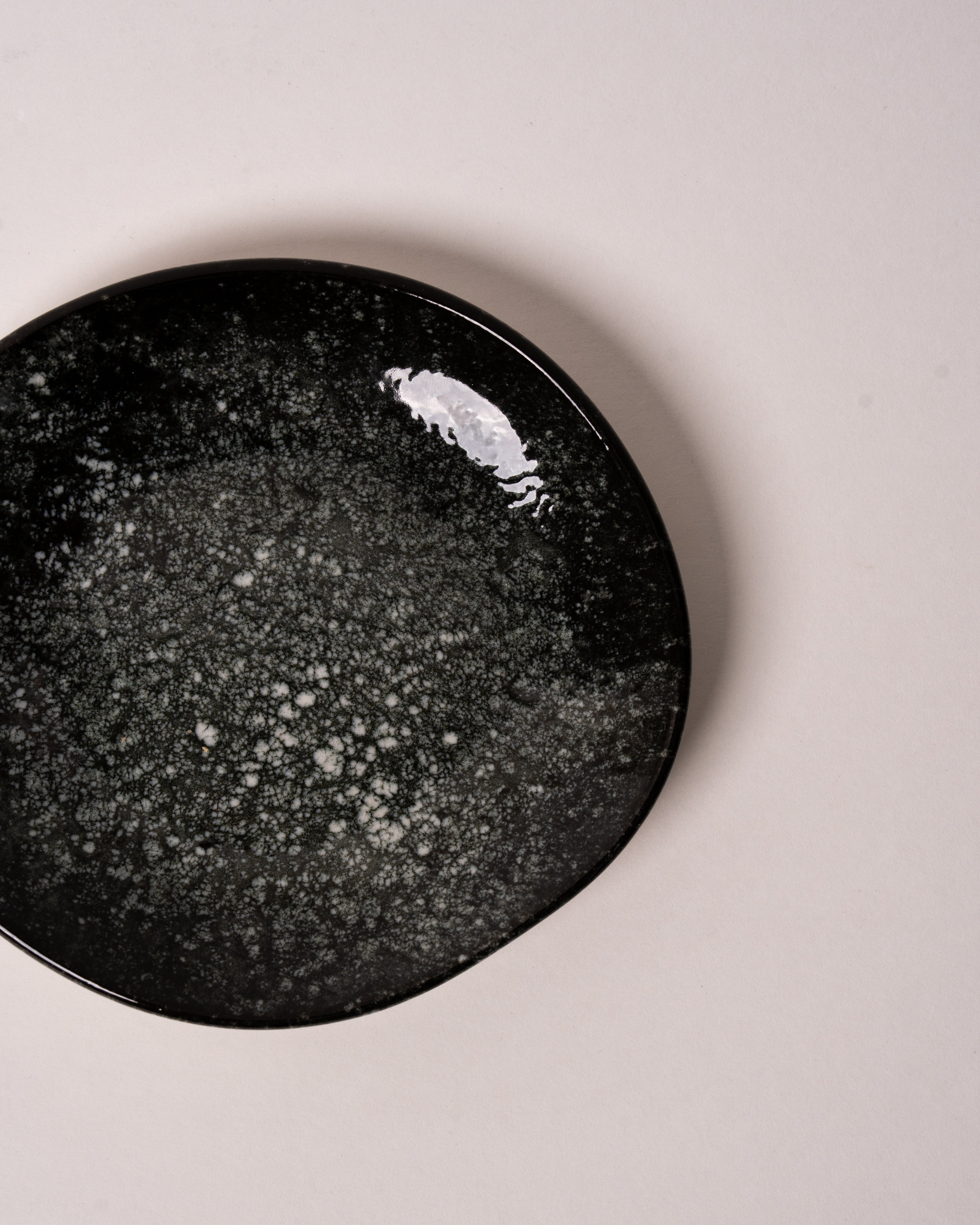 Cosmos porcelain small plate in grey speckled glaze, overhead view