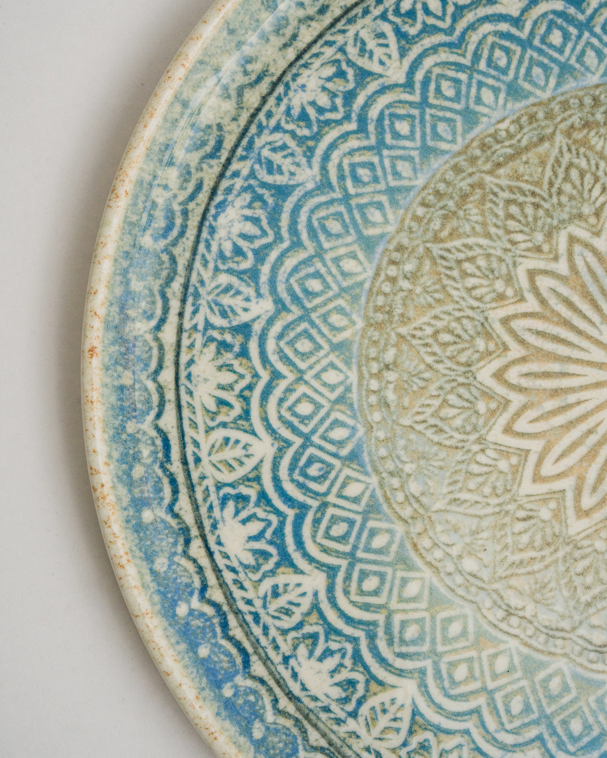 Overhead view of Embroideries of Atlantis porcelain pizza plate, full pattern visible