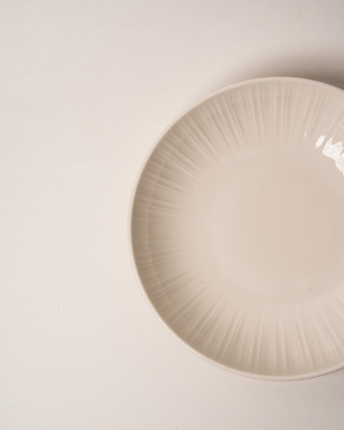 Angled view of Iris porcelain bistro bowl, matte cream finish