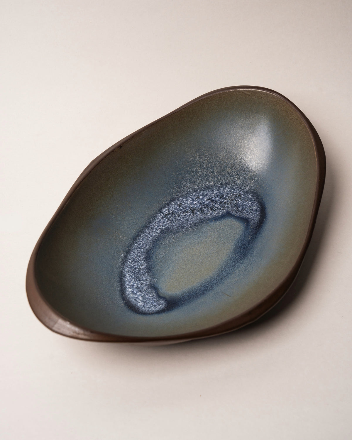 Tilted view of Lagoon porcelain bistro bowl, blue glaze detail
