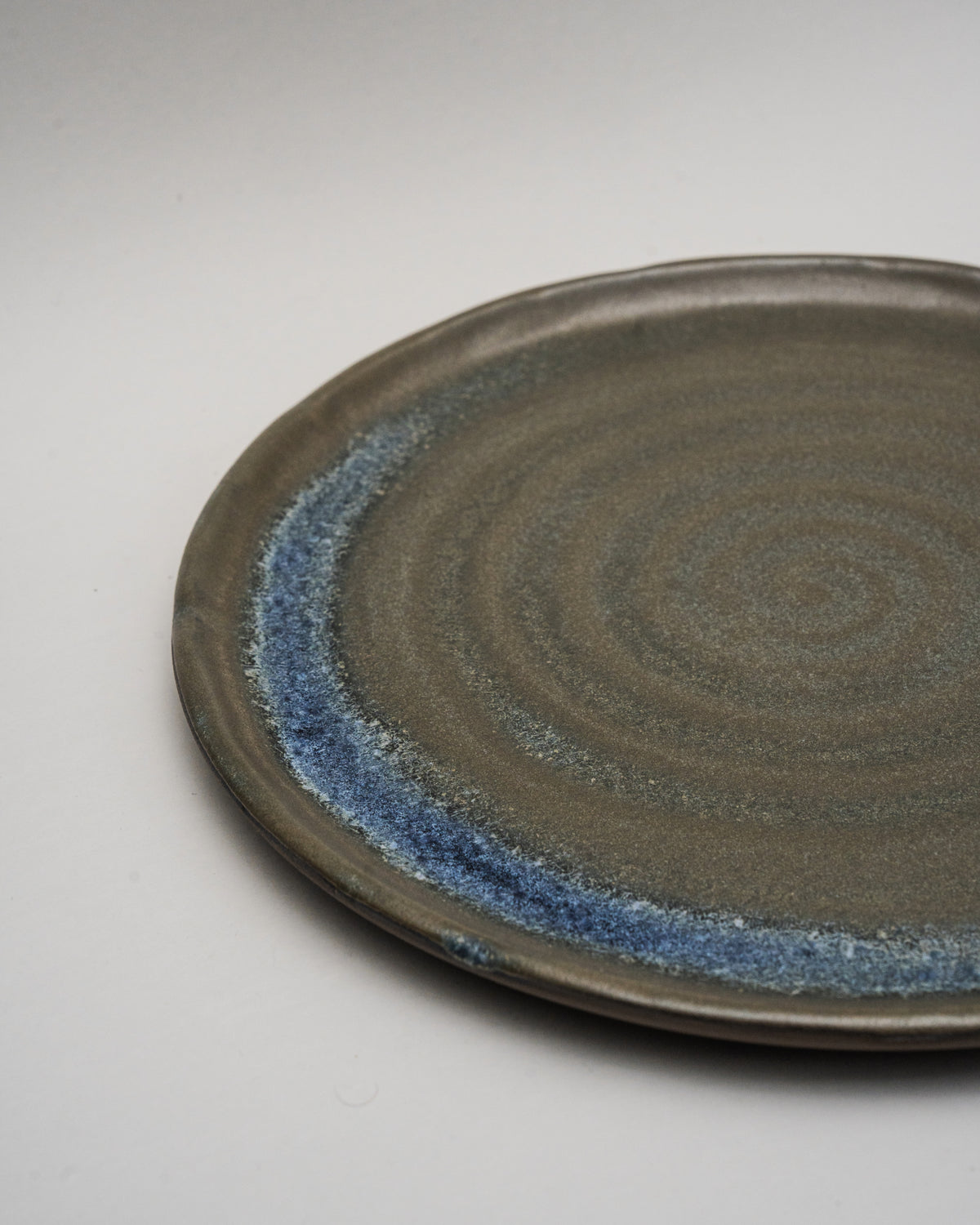 Side view of Lagoon porcelain dinner plate, blue rim detail