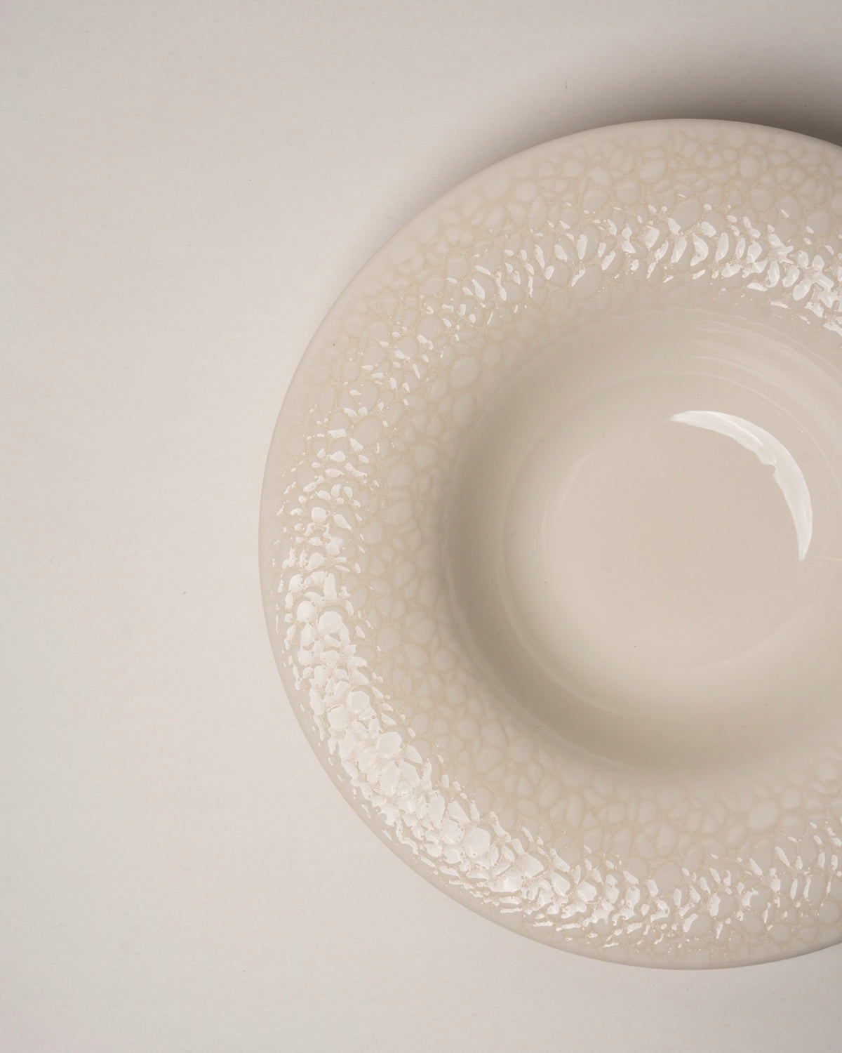 Angled view of Marlena porcelain bistro plate, matte cream finish