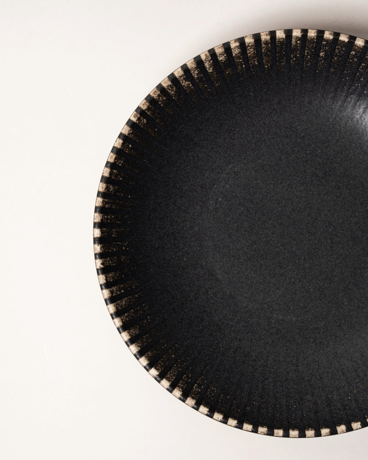 Angled overhead view of Obsidian porcelain bowl, beaded rim visible