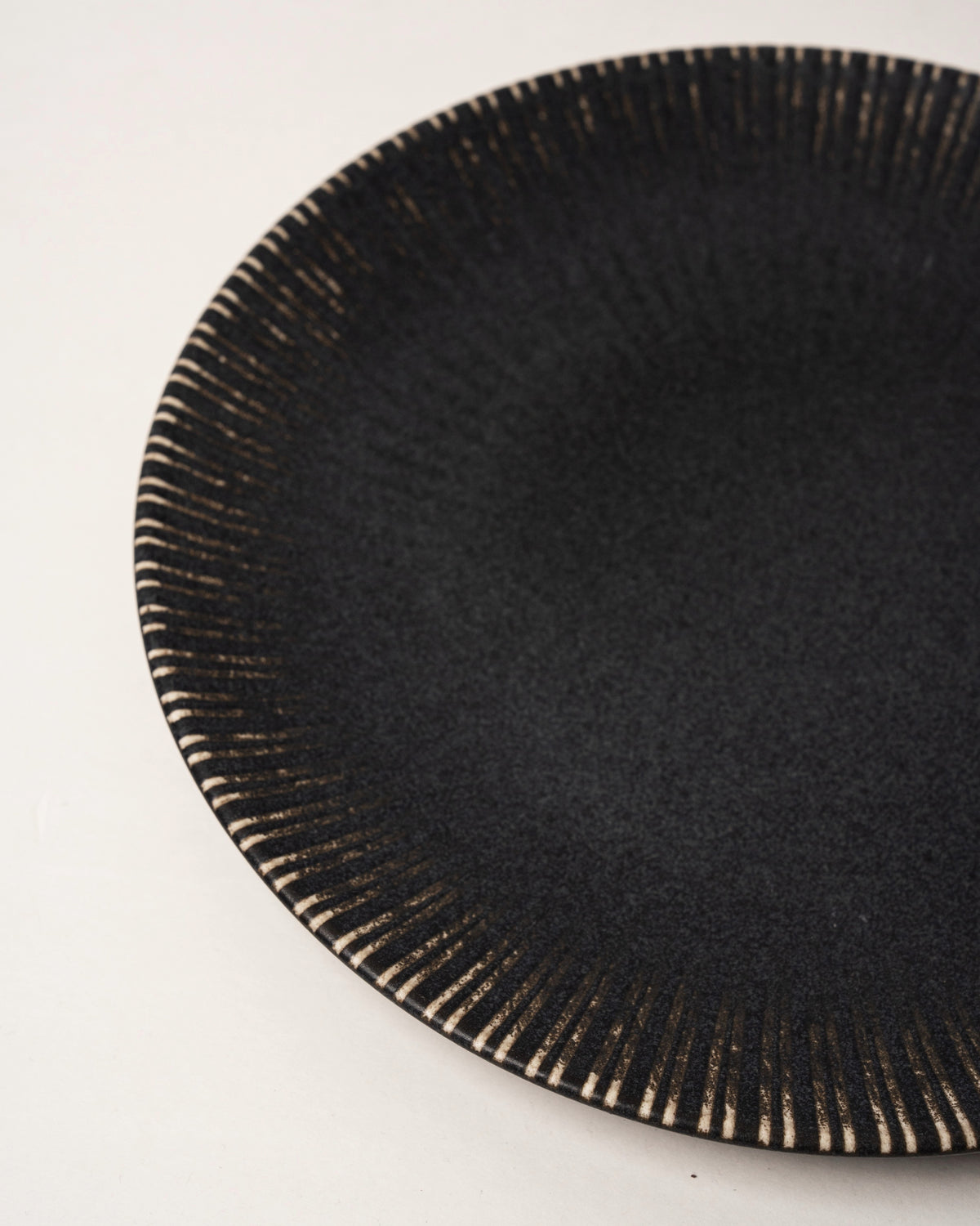 Side view of Obsidian porcelain dinner plate, matte black finish