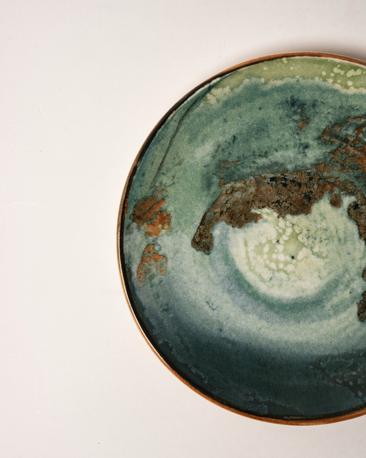 Overhead view of Pelagos porcelain plate, teal and gold pattern