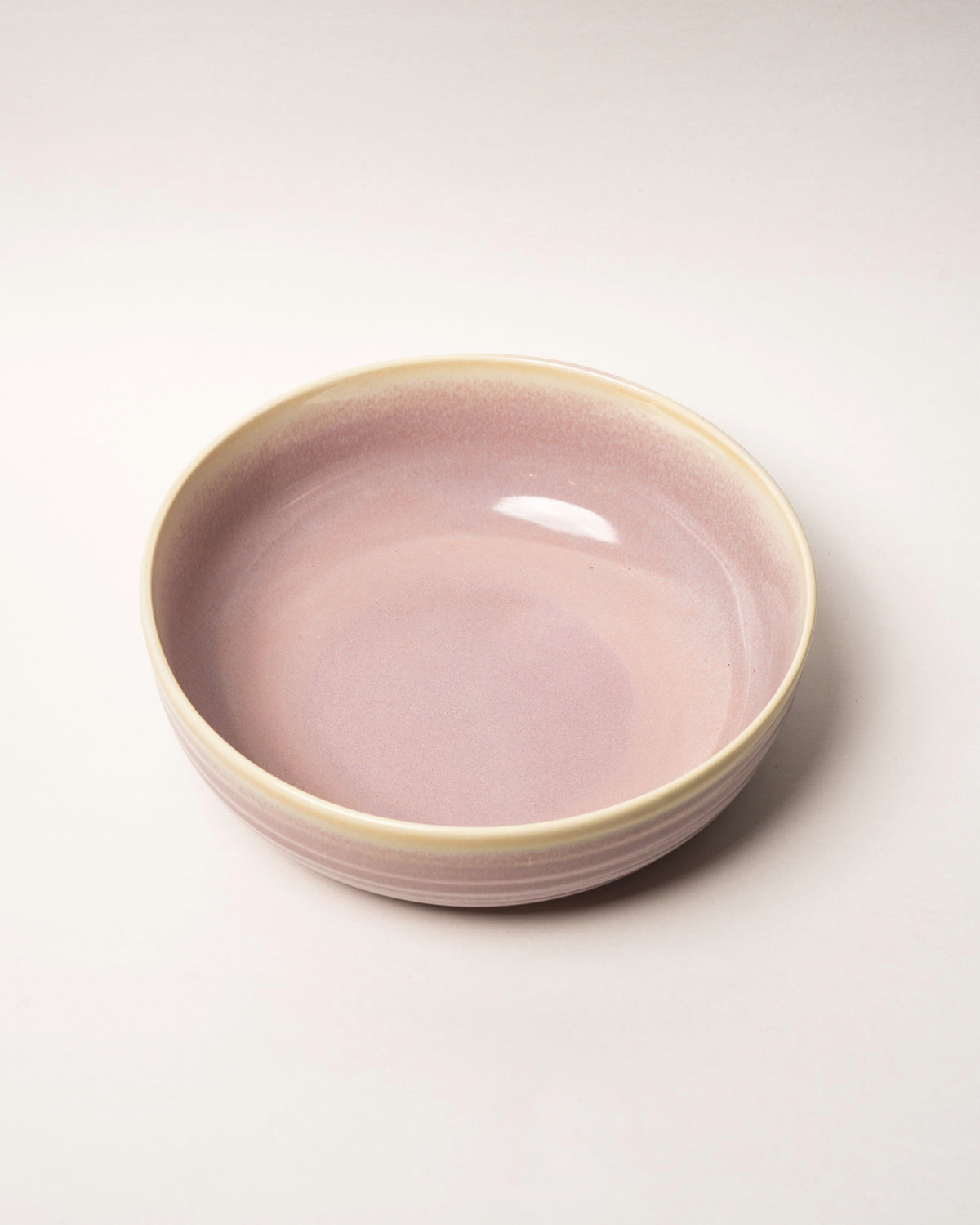 Side profile of Pink Pott porcelain fruit bowl, pink glaze visible