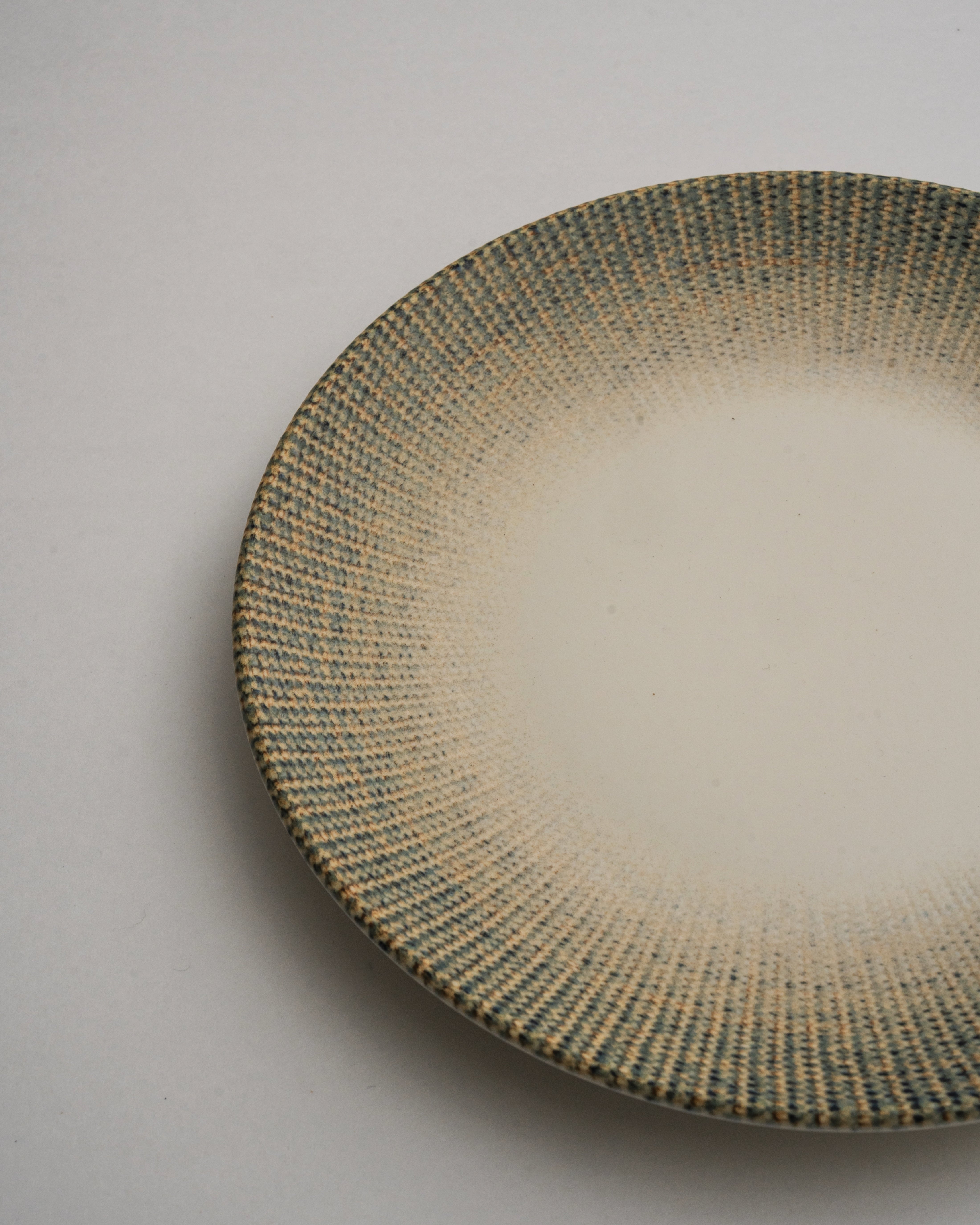 Angled view of Python porcelain dinner plate showing textured rim detail