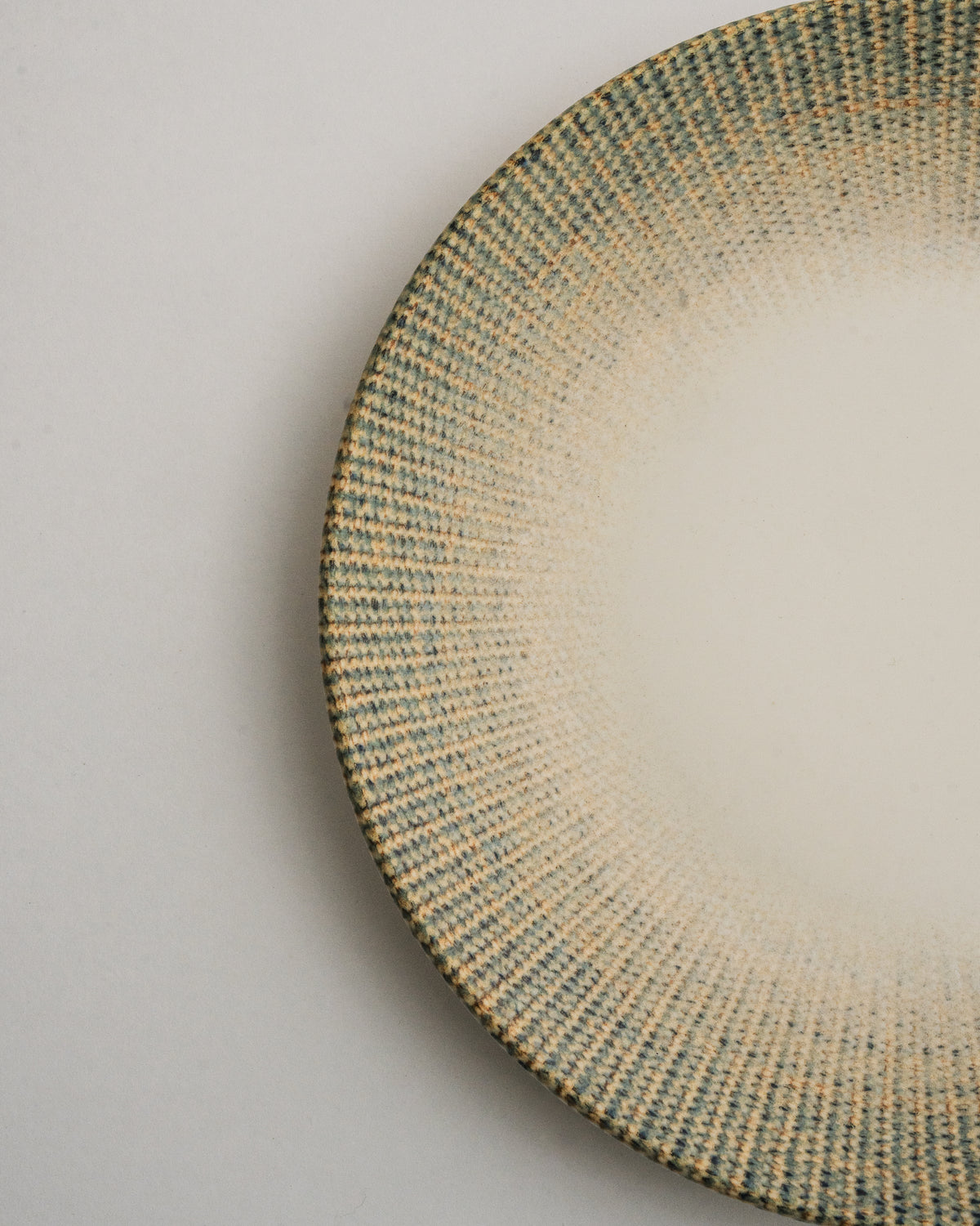 Overhead view of Python porcelain dinner plate, olive rim and cream center