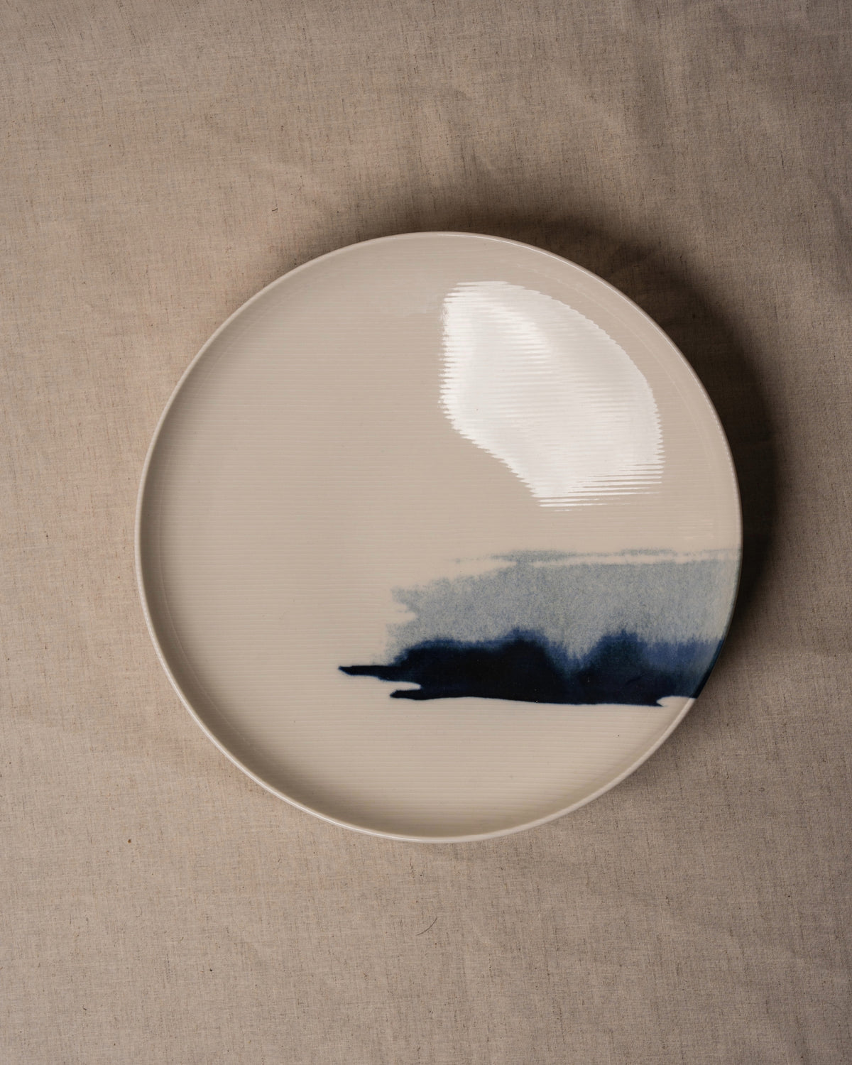 Close-up of The Wave porcelain bistro bowl, blue wave brushstroke detail