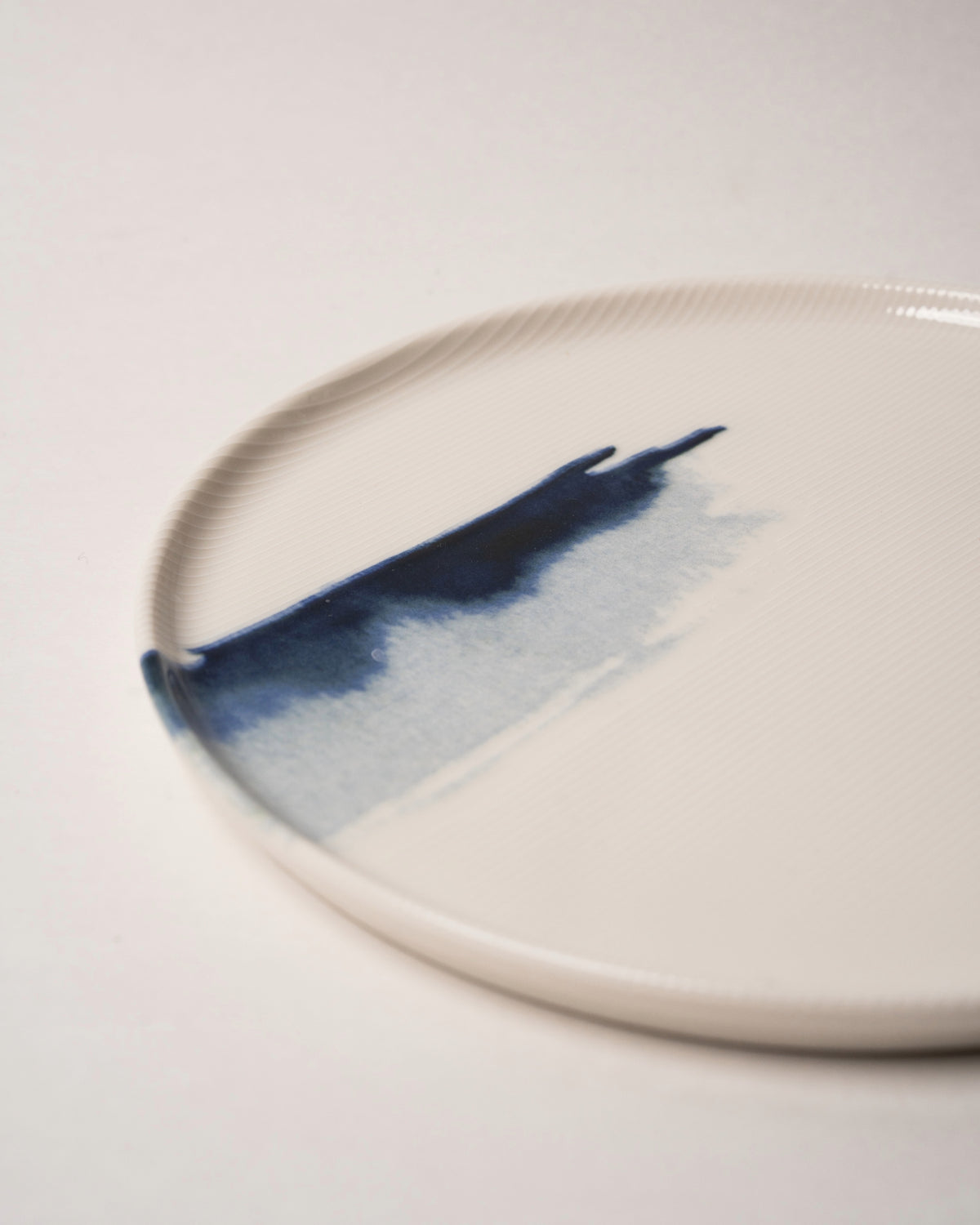 Overhead view of The Wave porcelain dinner plate, wave motif visible