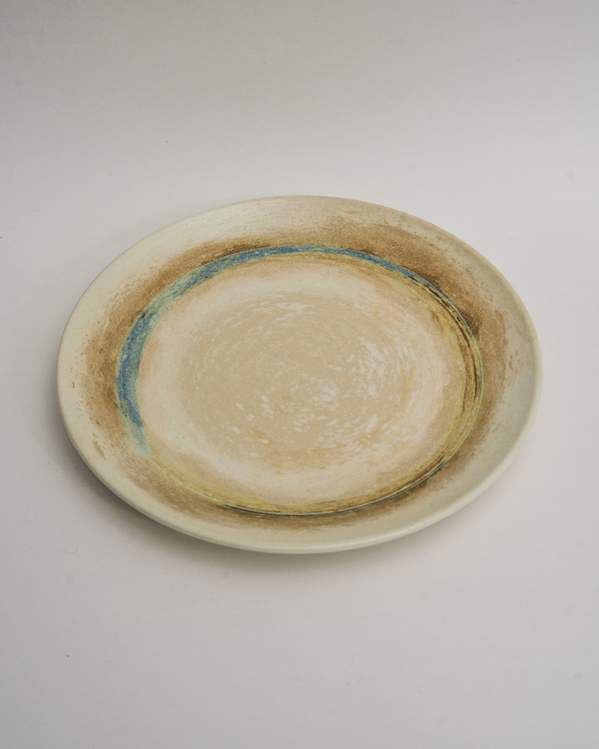 Side view of Tranquil porcelain dinner plate, blue rim detail